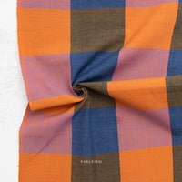 Checkered fabric with orange, blue, and brown squares on a white background, featuring the brand 'Fableism'.