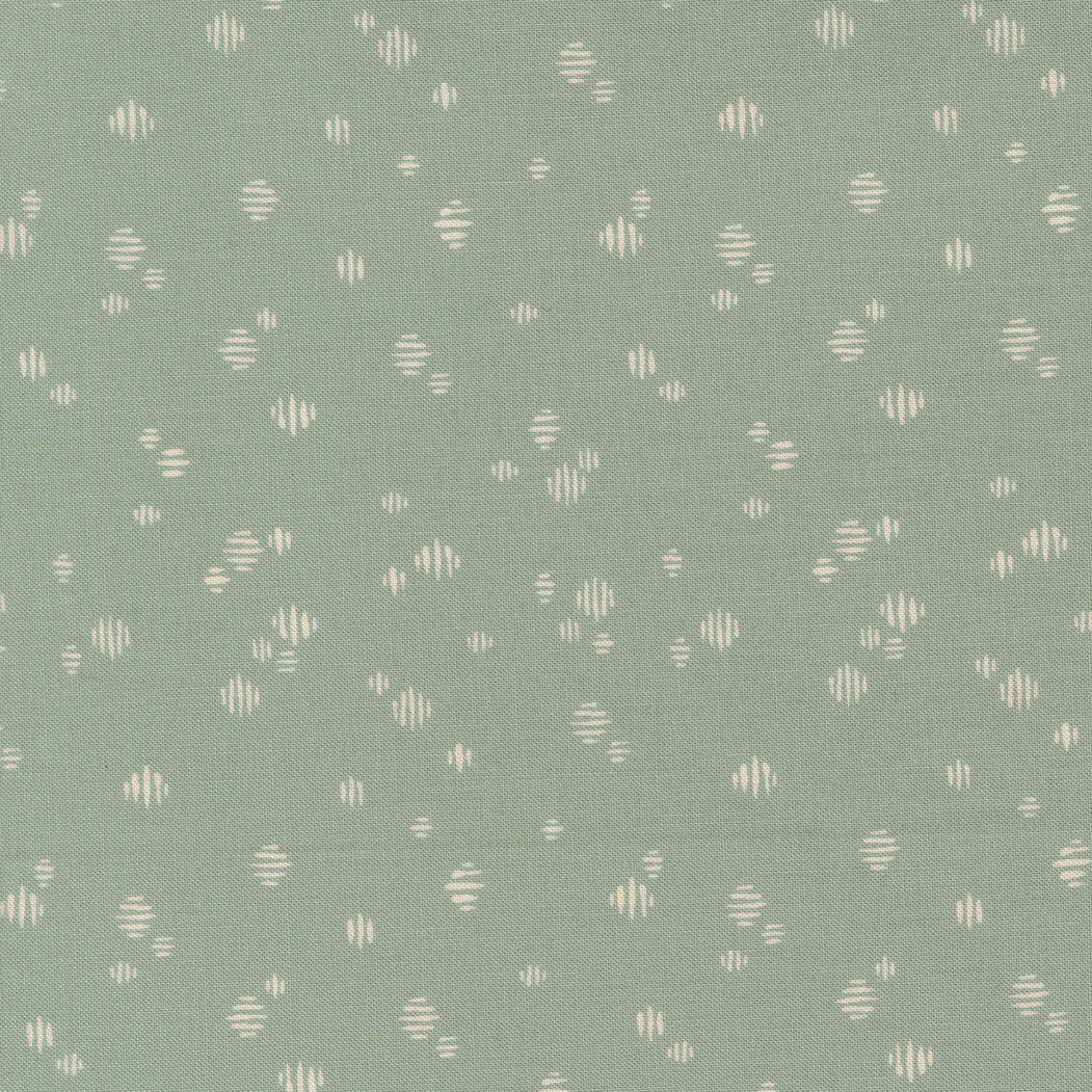 Patterned fabric with small geometric shapes on a green background