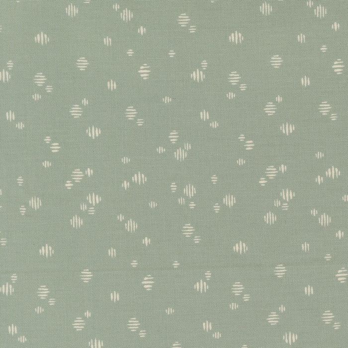 Patterned fabric with small geometric shapes on a green background
